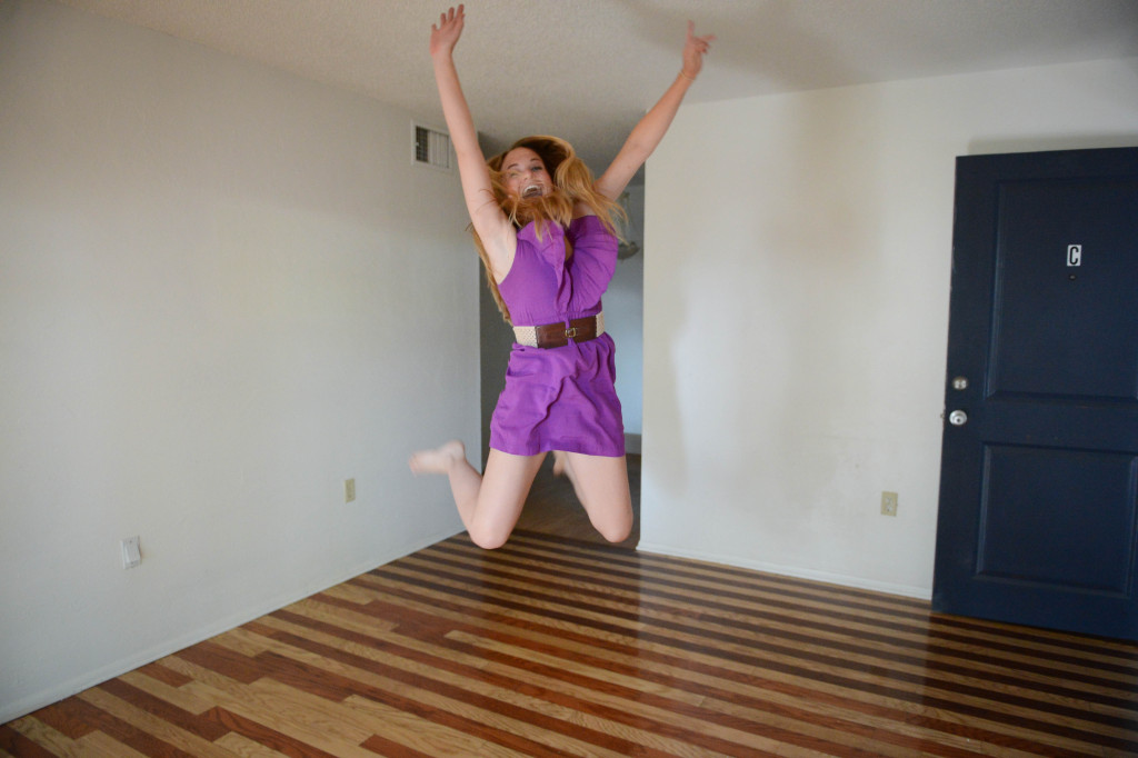 Shelby Webb jumps for joy inside her new apartment.  Photo by Rachel O'Hara