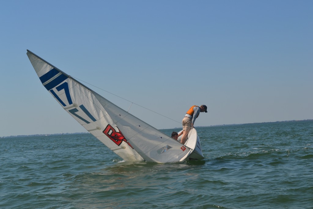 Michael Long uses his body weight to keep a sailboat from capsizing in Sarasota Bay.