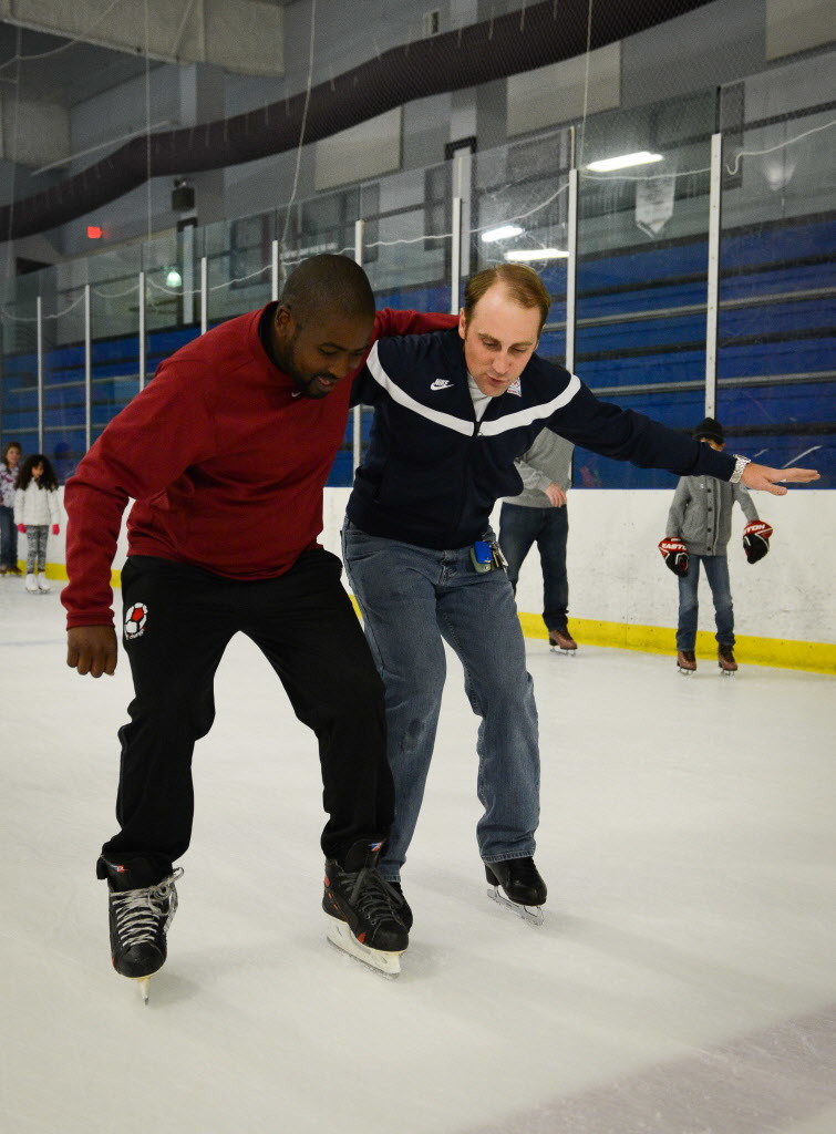 Olympian Mark Ladwig helps Sylvester Nogada, from South Africa, skate around the ice rink Saturday, June 13 at the Sports and Social Impact Festival at the Ellenton Ice and Sports Complex.   (June 13, 2015) (Herald-Tribune staff photo by Rachel S. O'Hara)