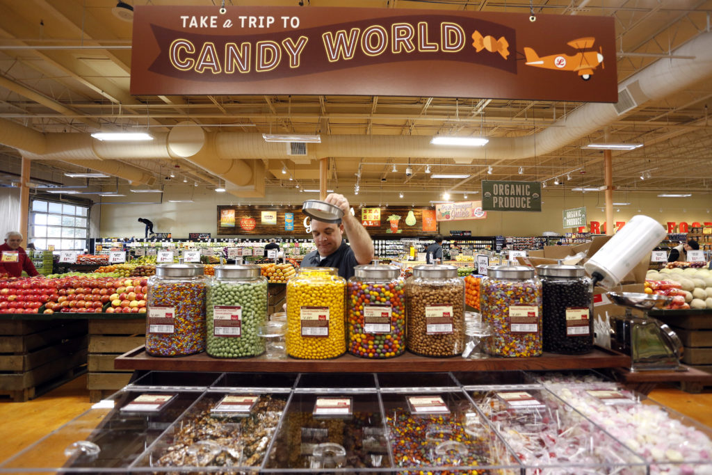 Employee Daniel Sinclair offers samples of various candies and trail mixes, Tuesday, January 6, 2015 during the grand opening of Lucky's Market at 1459 NW 23rd Avenue in Gainesville, Fla. Erica Brough/Gainesville Sun