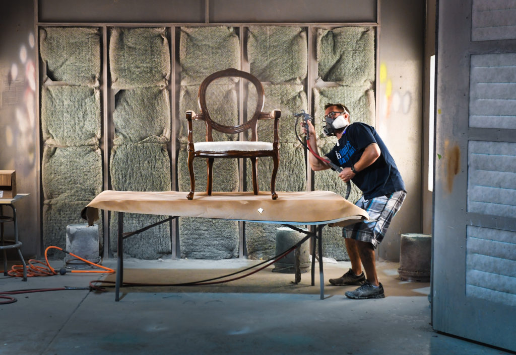 Chris Hammond applies wood sealant to a Louis IX style chair at Mission Avenue Studios. Herald-Tribune staff photo / Dan Wagner